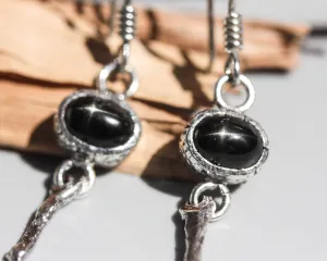 Oval Star Diopside Earrings, featuring a silver bezel setting and silver sticks and hooks on the top